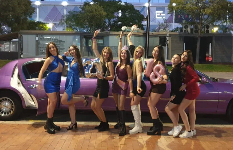 "Grupo de chicas celebrando un cumpleaños en una limusina lila en Barcelona, imagen tomada desde el exterior durante el servicio de alquiler.