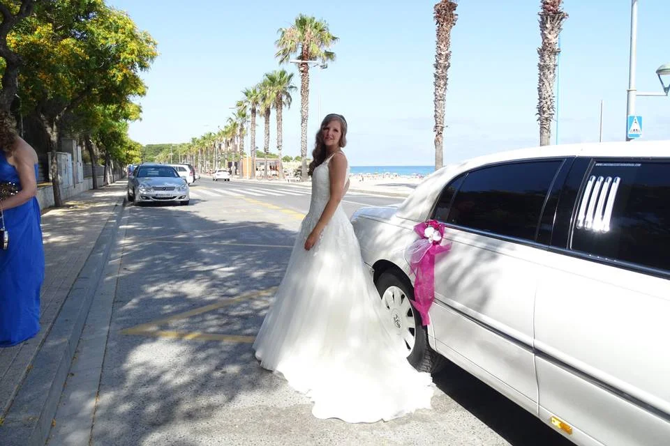 Chica disfrutando de una elegante limusina Lincoln en la playa – Limusinas Bodas Barcelona.