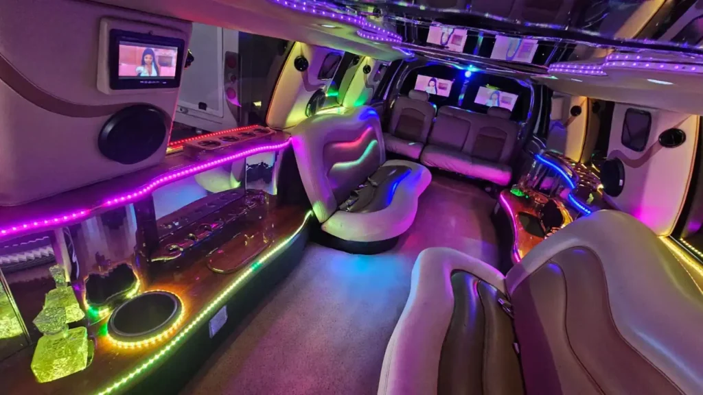 Interior de limusina Ford tipo Hummer con tapicería elegante, luces LED y copas preparadas para la celebración