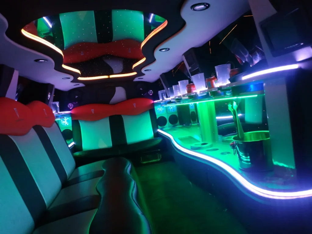 Interior de limusina Pontiac blanca con luces LED verdes y ambiente festivo en Barcelona