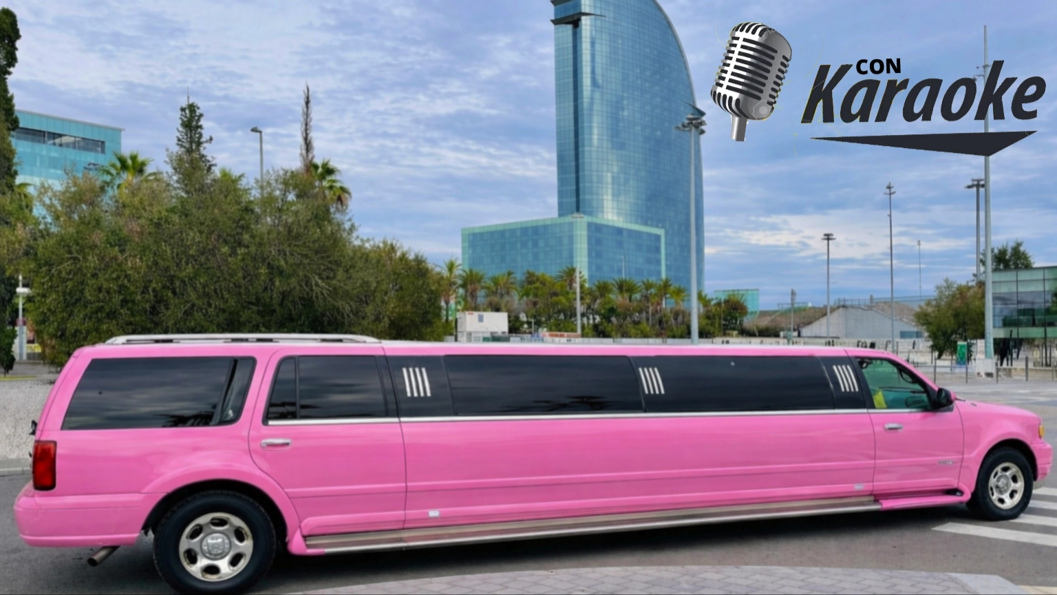 Limusina Hummer rosa frente al icónico Hotel W de Barcelona, símbolo de lujo y estilo para eventos, despedidas y celebraciones exclusivas.