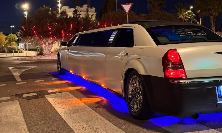 Vista lateral de la limusina Chrysler 300C blanca en Barcelona, vehículo de lujo para eventos